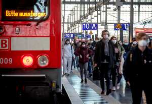 Pasajeros con mascarillas caminan por un andén de la principal estación de trenes de Fráncfort, Alemania.". (AP Foto/Michael Probst)