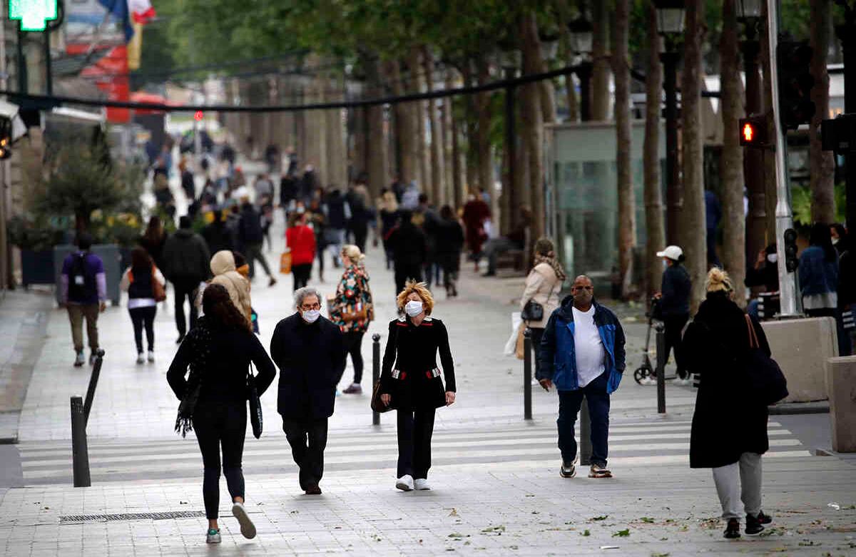 Gente camina por la avenida Champs Elysee, en París, el lunes 11 de mayo de 2020. Foto: Christophe Ena/AP