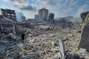 Palestinos caminan sobre los escombros de edificios destruidos por los ataque aéreos de Israel en Gaza, el martes 10 de octubre de 2023. (AP Foto/Hassan Eslaiah)