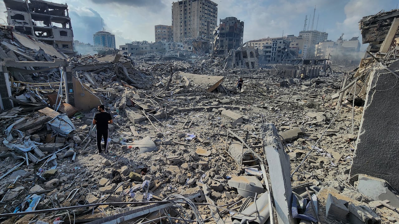 Palestinos caminan sobre los escombros de edificios destruidos por los ataque aéreos de Israel en Gaza, el martes 10 de octubre de 2023. (AP Foto/Hassan Eslaiah)
