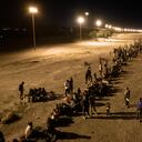 En una vista aérea, los inmigrantes esperan cerca de la valla fronteriza entre Estados Unidos y México, con la esperanza de que los agentes fronterizos de Estados Unidos procesen su asilo el 8 de mayo de 2023 en El Paso, Texas.
