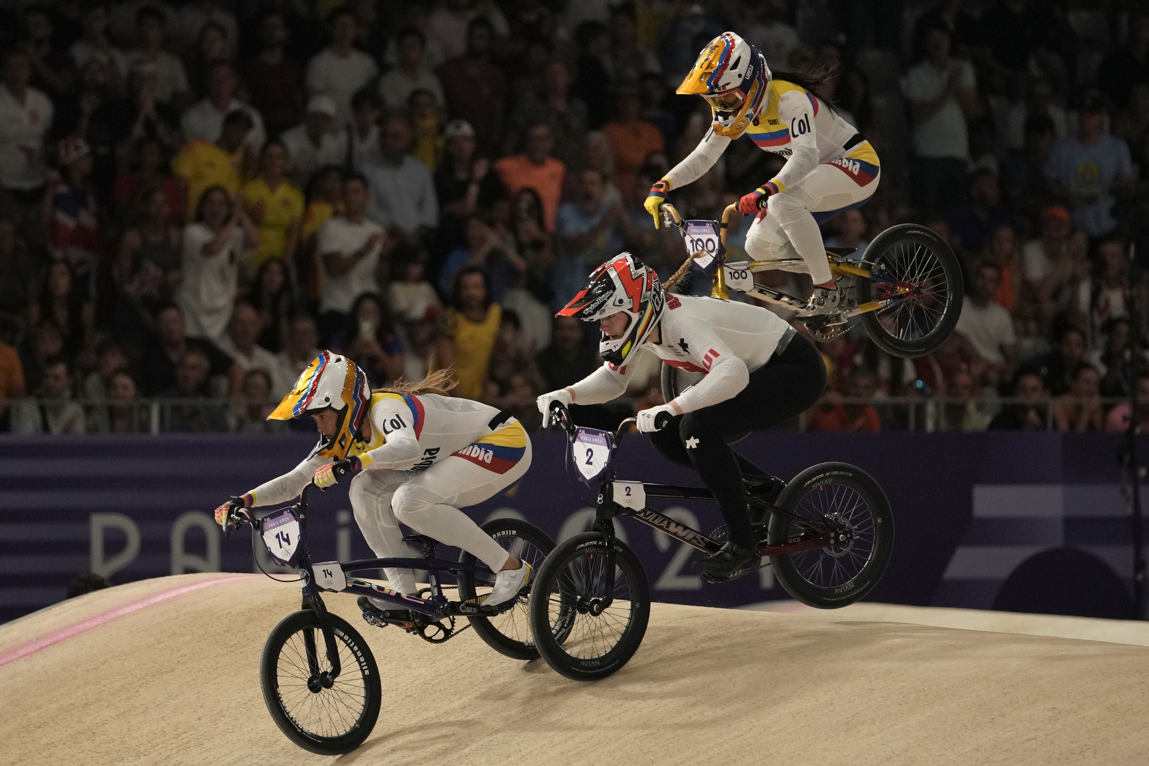 Gabriela Bolle Carrillo of Colombia, left, leads Zoe Claessens of Switzerland and Mariana Pajon Londono of Colombia during a women's BMX racing event, at the 2024 Summer Olympics, Thursday, Aug. 1, 2024, in Saint-Quentin-en-Yvelines, France. (AP Photo/Thibault Camus)