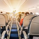 Commercial aircraft cabin with rows of seats down the aisle. morning light in the salon of the airliner. economy class