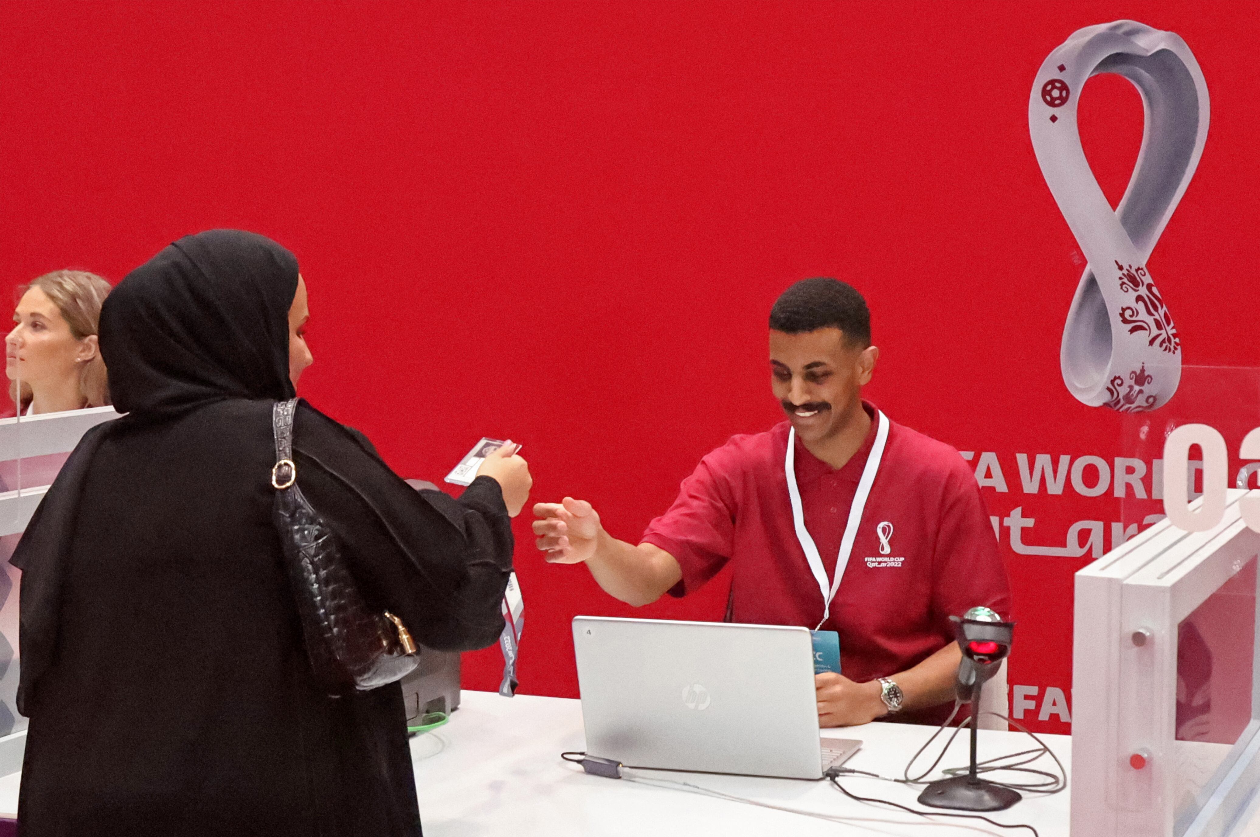 An employee works at the Hayya service centre which assists fans attending this year's Qatar FIFA World Cup, in the capital Doha on October 16, 2022. - Qatar said that more than 1.5 million people have applied for the compulsory pass for the football World Cup, that begins on November 20. (Photo by KARIM JAAFAR / AFP)
