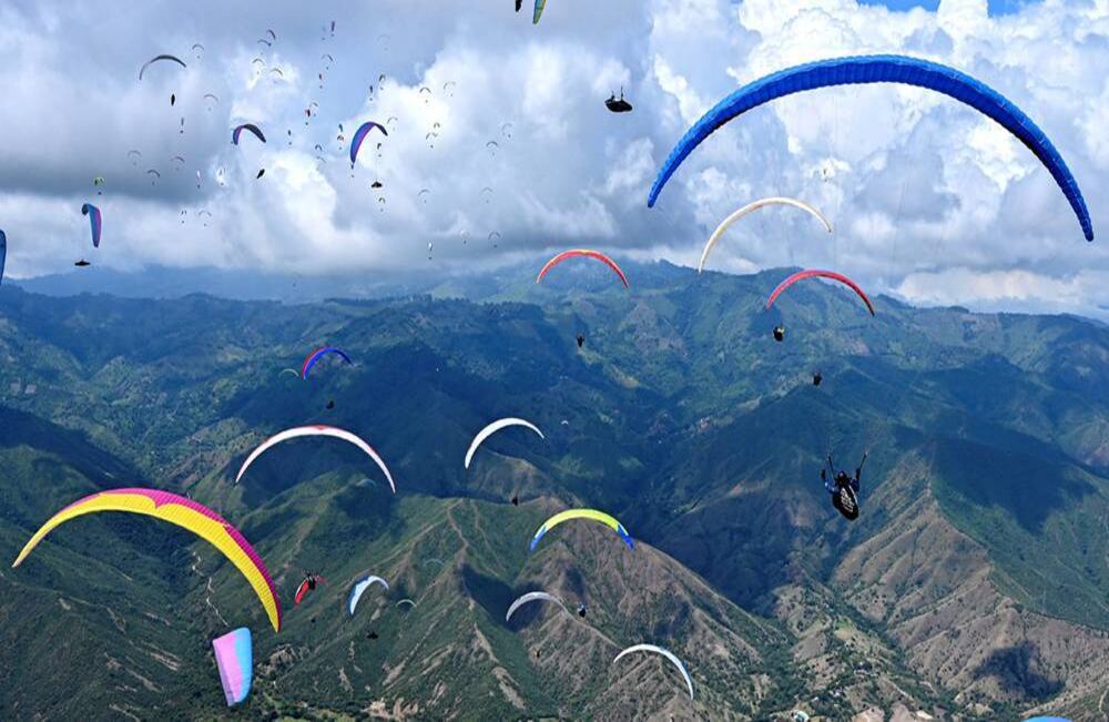 Espectáculo multicolor al aire. Pilotos de parapente vuelan sobre las montañas en el municipio de Roldanillo, en el departamento del Valle del Cauca, Colombia, durante el British Winter Open, el 25 de enero de 2020. Esta competencia, que involucra a los 130 mejores pilotos del mundo, se está realizando en Colombia por segunda vez. Foto: Luis Robayo/ AFP.