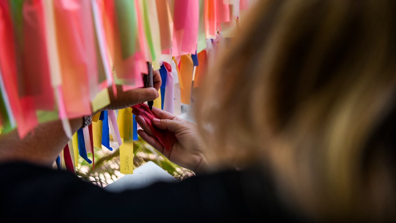 Una mujer decidió hacer homenaje a los muertos de covid con cintas de colores.
