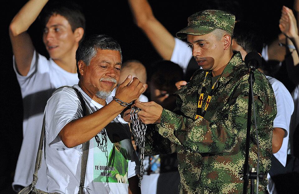 Pablo Emilio Moncayo elimina las cadenas que su padre Gustavo Moncayo llevaba simbólicamente, después de su liberación, el 30 de marzo de 2010. (Foto: Luis Robayo)