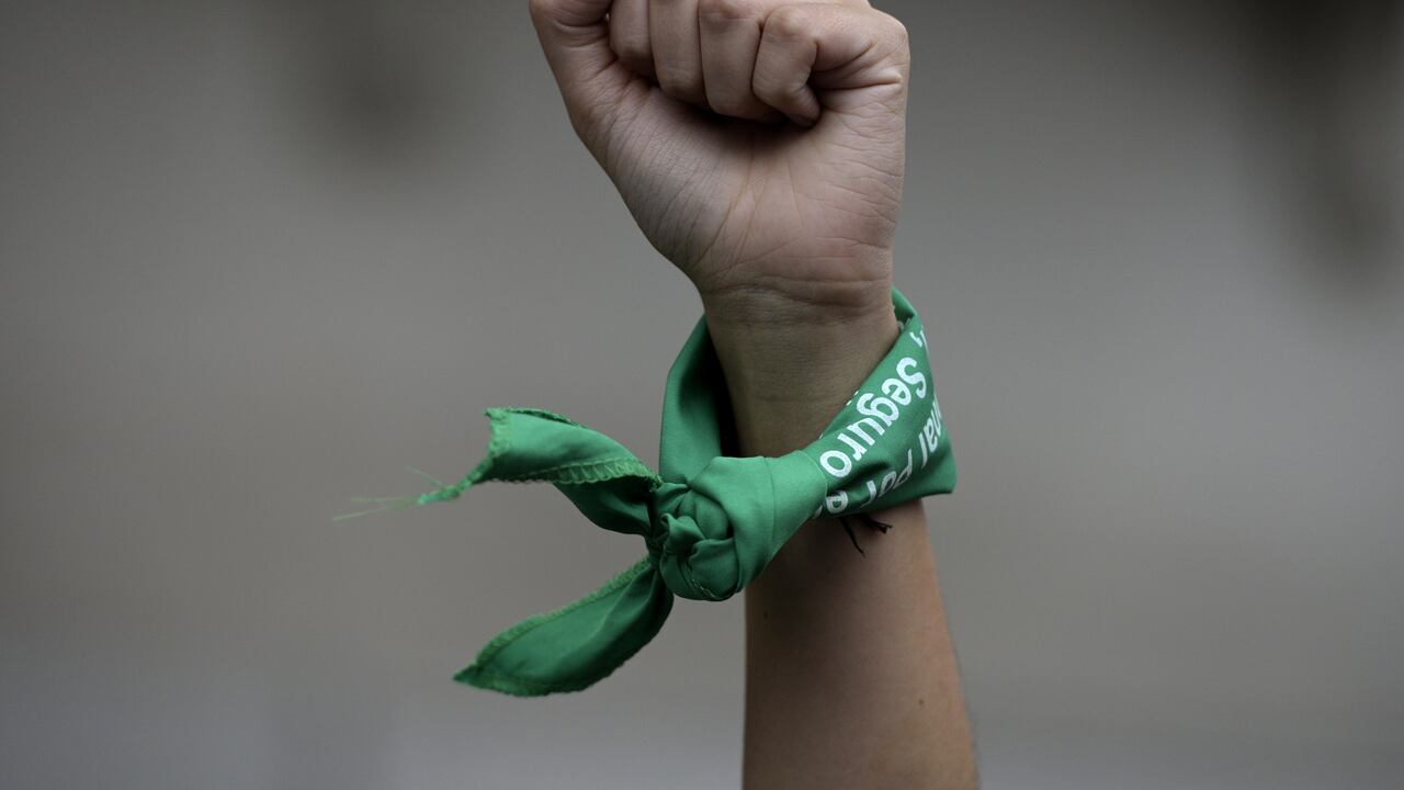 (FILES) In this file picture taken on March 9, 2020 a woman rises her fist with a green headscarves to demand the legalization of abortion during a demonstration in front of the Congress in Buenos Aires during a women's strike in Argentina. - The Argentine Congress debates on a government-backed new draft bill to legalize abortion on December 1, 2020, an issue that has bitterly divided the traditionally Catholic South American nation. Under a law first passed in 1920, Argentina permits abortions only in cases of rape or danger to the life of the mother. (Photo by Juan MABROMATA / AFP)