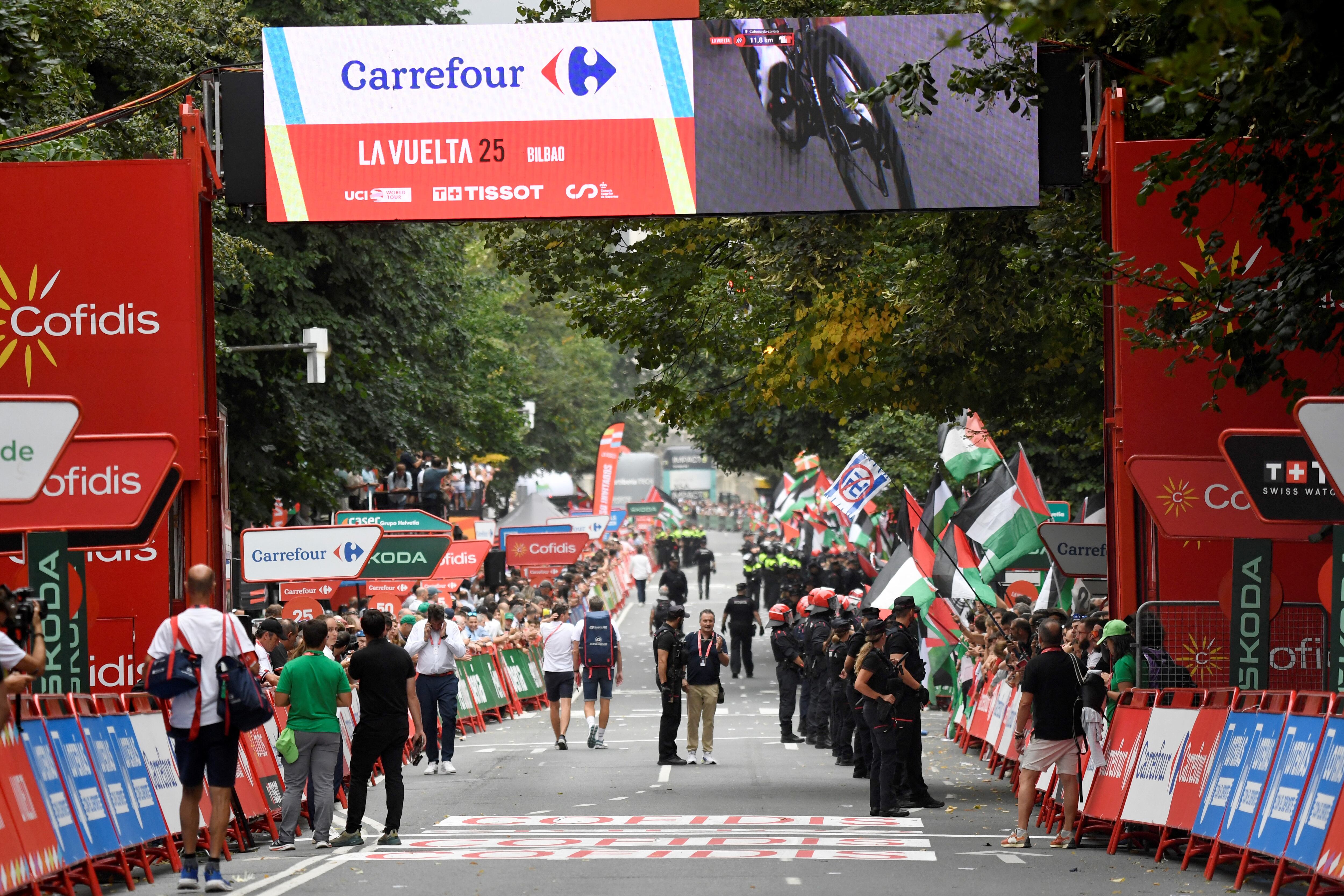 Pro-Palestinian protesters holding Palestinian and Basque flags demonstrate at the finish line causing the Vuelta 11th stage to be shortened 3 kms before the line, in Bilbao, on September 3, 2025. Pro-Palestinian protest forces Vuelta stage to be shortened and to take the time at 3 kilometres before the linea, according to the organisers, AFP reports. (Photo by ANDER GILLENEA / AFP)