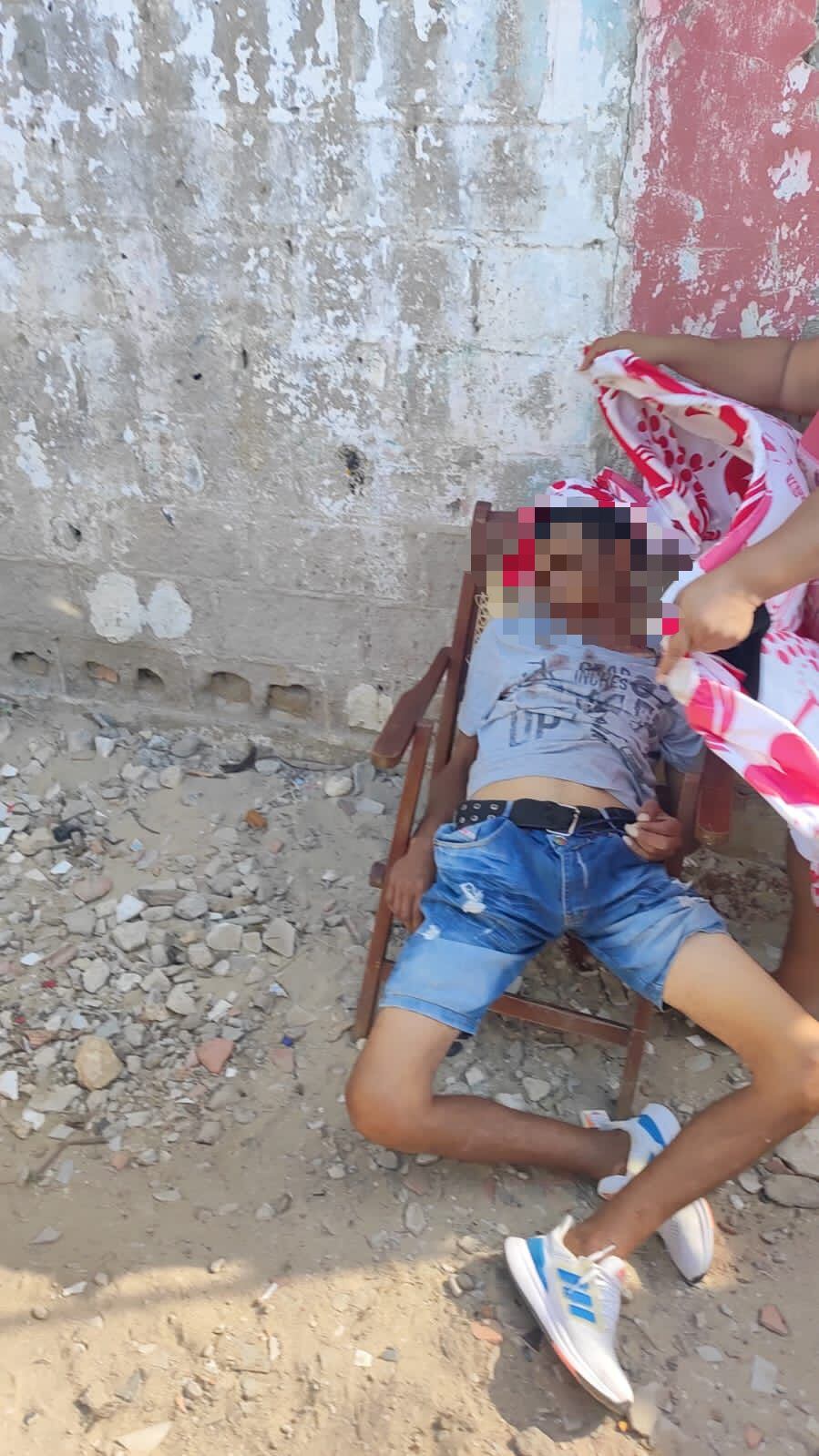 Uno de los muertos quedó en una silla cuando fue baleado.