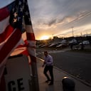 A voter looks at an informational leaflet passed out by a camping worker while entering a polling site on Election Day, Tuesday, Nov. 5, 2024, in Dearborn, Mich. (AP Photo/David Goldman)