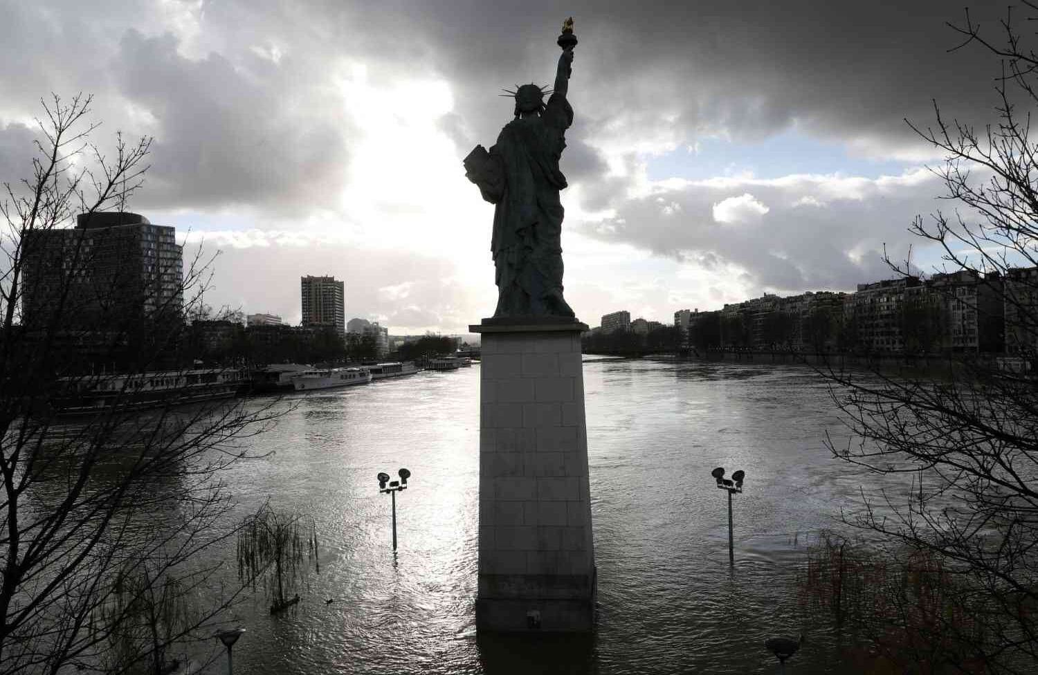 Una fotografía tomada el 26 de enero de 2018, muestra el Ile aux Cygnes inundado y las orillas del río Sena con una maqueta de la Estatua de la Libertad en París.