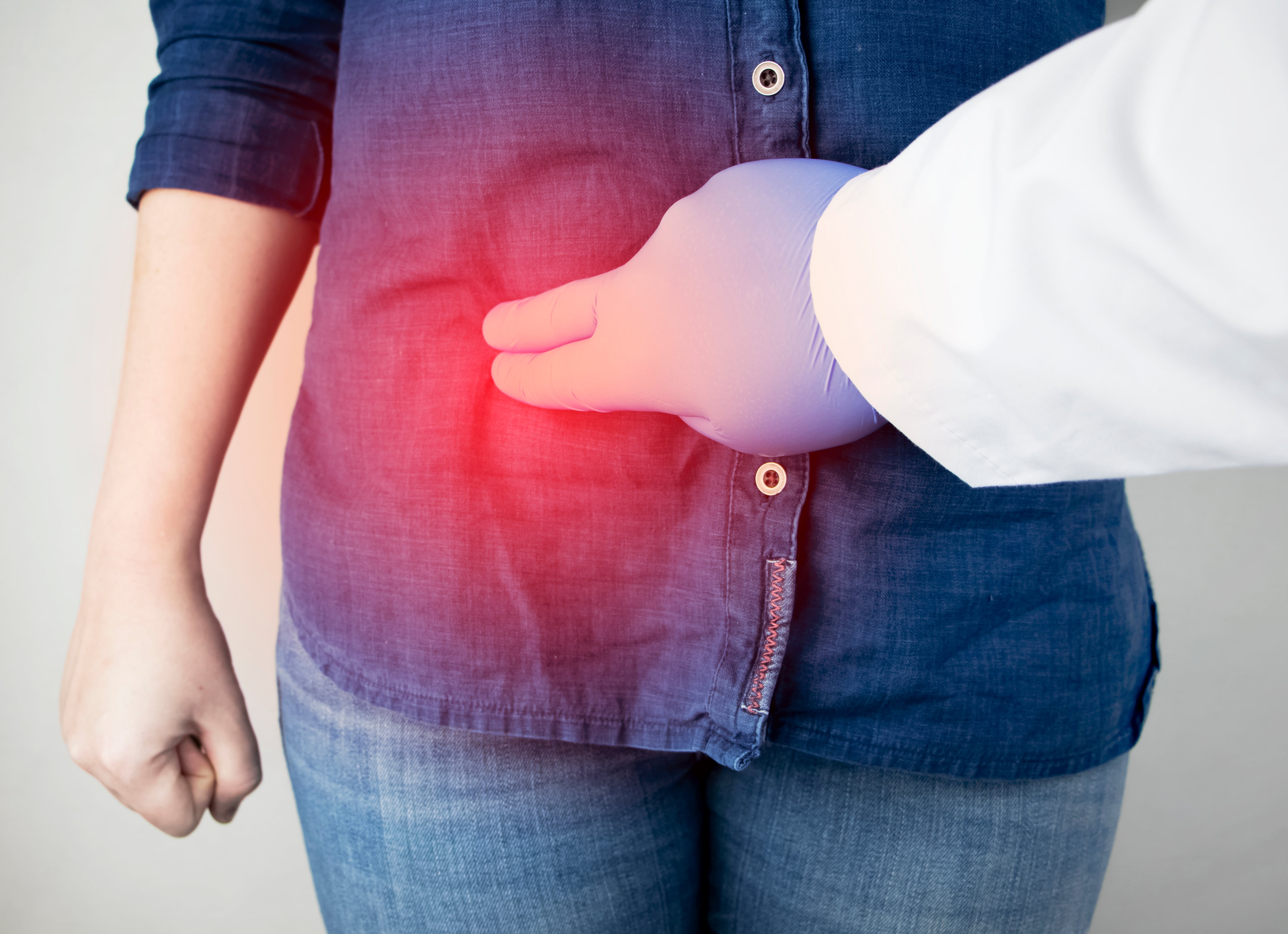 Síndrome de dolor en la enfermedad hepática. Examen hepatólogo. Una mujer le agarra el costado derecho por debajo de las costillas. Dolor en el higado.