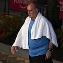 Marcelo Bielsa, técnico de Uruguay, usando una toalla mientras ingresa al hotel de concentración.