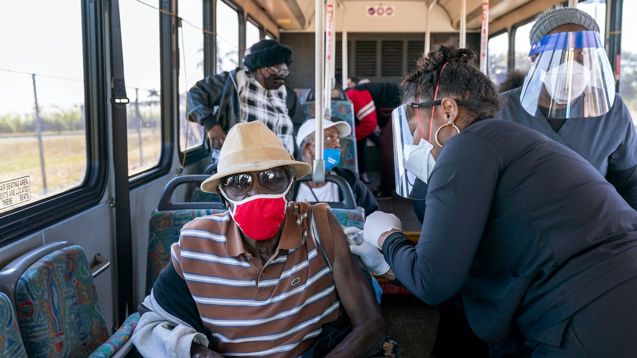 Una persona mayor recibe una vacuna COVID-19 de un trabajador de la salud después de llegar en un autobús a un sitio de vacunación en el Estadio Anquan Boldin en Pahokee, Florida, Estados Unidos.