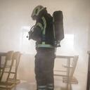 Bombero atiende un incendio en un establecimiento educativo. (Imagen de referencia)