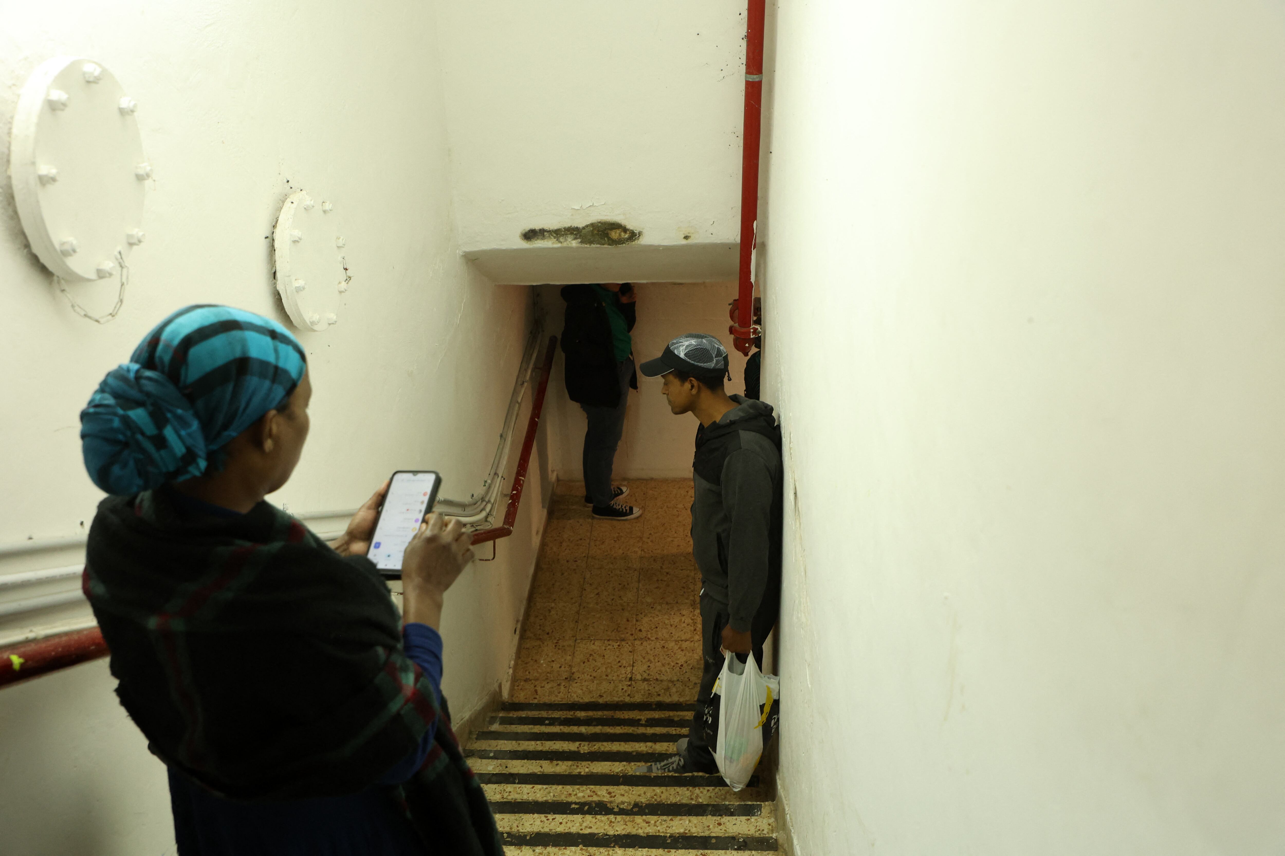 La gente ingresa a un refugio antiaéreo en la ciudad de Ashdod, en el sur de Israel, el 10 de mayo de 2023, mientras se lanzan cohetes hacia Israel desde la franja de Gaza. El ejército de Israel y los militantes de Gaza intercambiaron intensos disparos transfronterizos el 10 de mayo, con 22 palestinos muertos durante dos días en medio de la peor escalada de violencia que ha golpeado el territorio costero en meses. (Foto de GIL COHEN-MAGEN / AFP)