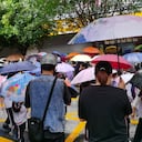 Los padres sostienen paraguas para recoger a los estudiantes en la puerta de la escuela mientras las clases de jardín de infantes se reanudan al mediodía en Qingyuan, provincia de Guangdong, en el sur de China, el 23 de abril de 202