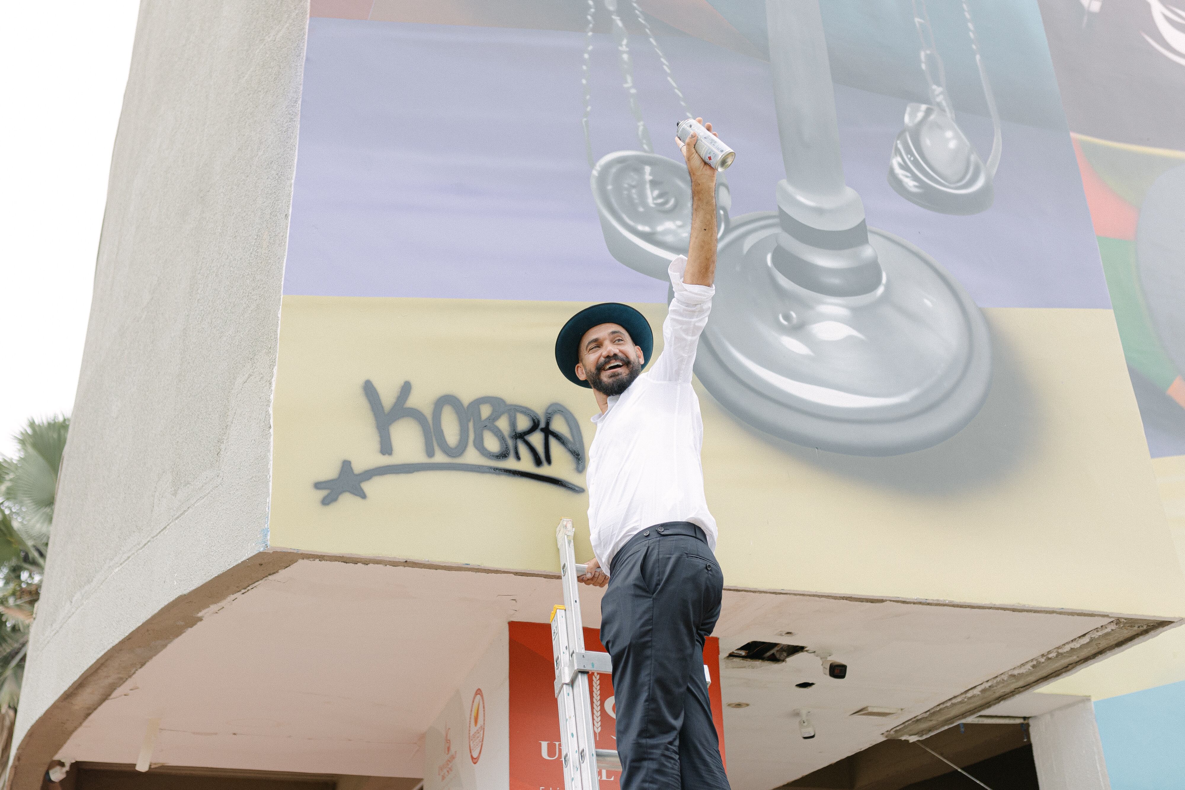 El muralista Kobra pasó por Montería, donde dejó su primera obra en Colombia, un homenaje al científico Elías Bechara Zainúm (1920-2013) y a la educadora Saray Castilla de Bechara (1929-2018), pareja que en la educación de la gente vio una prioridad y una oportunidad de construir paz. Fundaron la Universidad del Sinú hace 50 años.