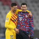Barcelona's Clement Lenglet, left, and Bayern's Robert Lewandowski laugh after the Champions League group E soccer match between Bayern Munich and FC Barcelona in Munich, Germany, Wednesday, Dec. 8, 2021. Bayern won 3-0. (AP Photo/Matthias Schrader)