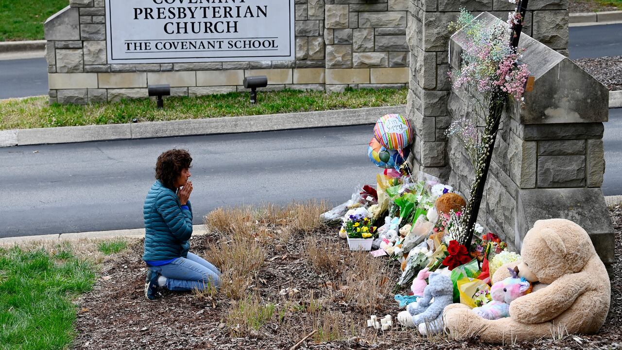 Robin Wolfeden reza frente a un monumento improvisado en la entrada de The Covenant School el martes 28 de marzo de 2023 en Nashville, Tennessee. (Mark Zaleski /The Tennessean via AP)