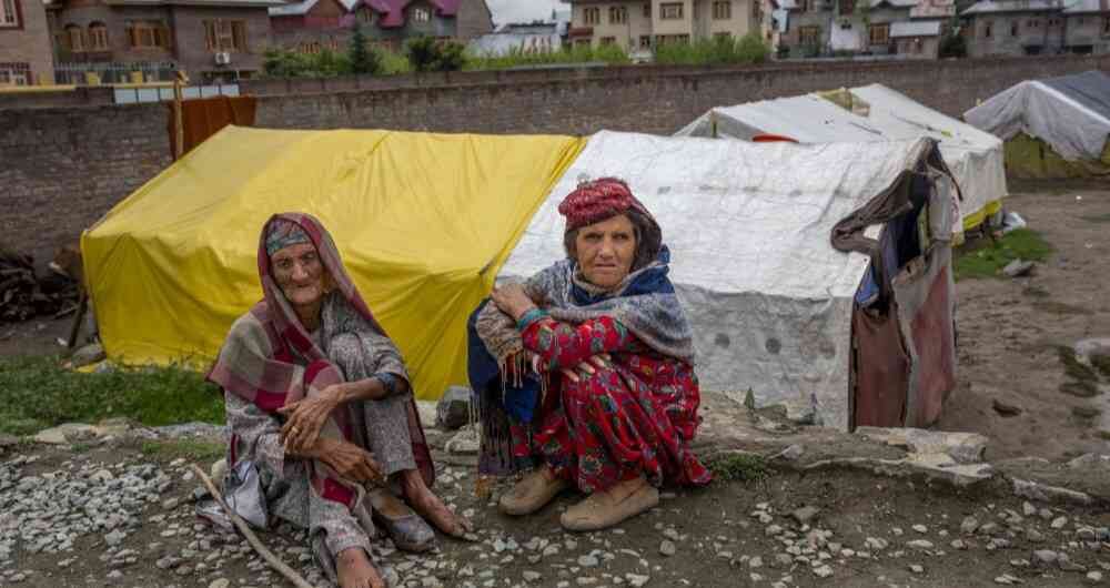 Gowri Khan, izquierda y Khatija Kashmiri Bakarwal. Las mujeres observan mientras se sientan fuera de su refugio temporal en las afueras de Srinagar, Cachemira, controlada por India.