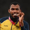 El colombiano Anthony José Zambrano, medallista de plata, muerde su medalla durante la ceremonia de entrega de medallas de los 400 metros masculinos durante los Juegos Olímpicos de Tokio 2020 en el Estadio Olímpico de Tokio el 6 de agosto de 2021 (Foto de Ina FASSBENDER / AFP).
