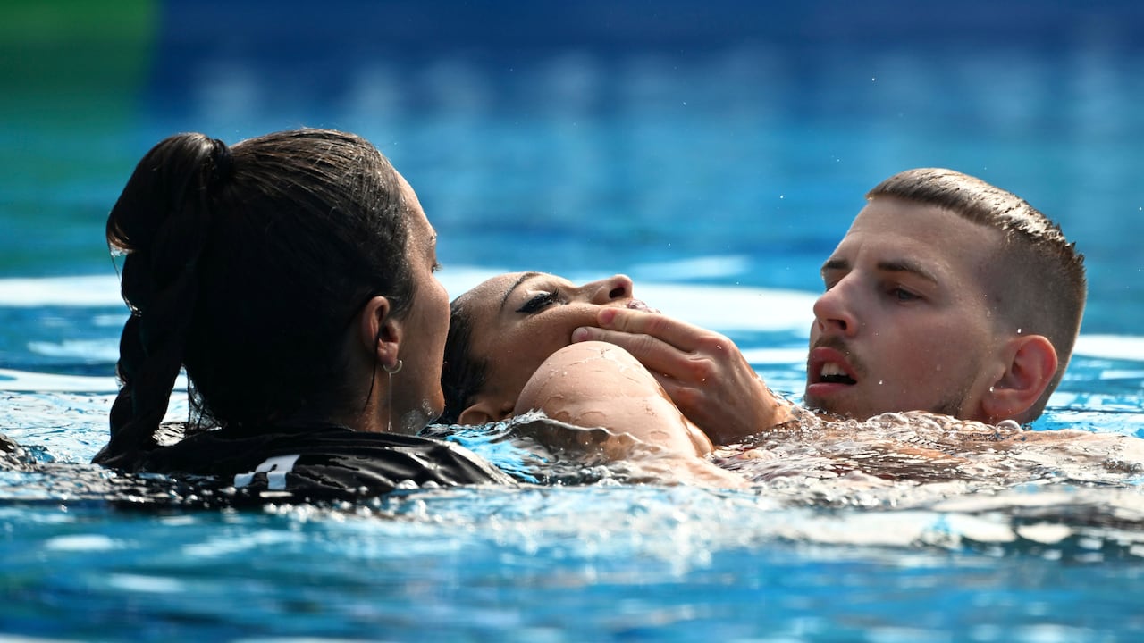 Anita Alvarez of United States, center, is taken from the pool after collapsing during the solo free final of the artistic swimming at the 19th FINA World Championships in Budapest, Hungary, Wednesday, June 22, 2022. (AP Photo/Anna Szilagyi)