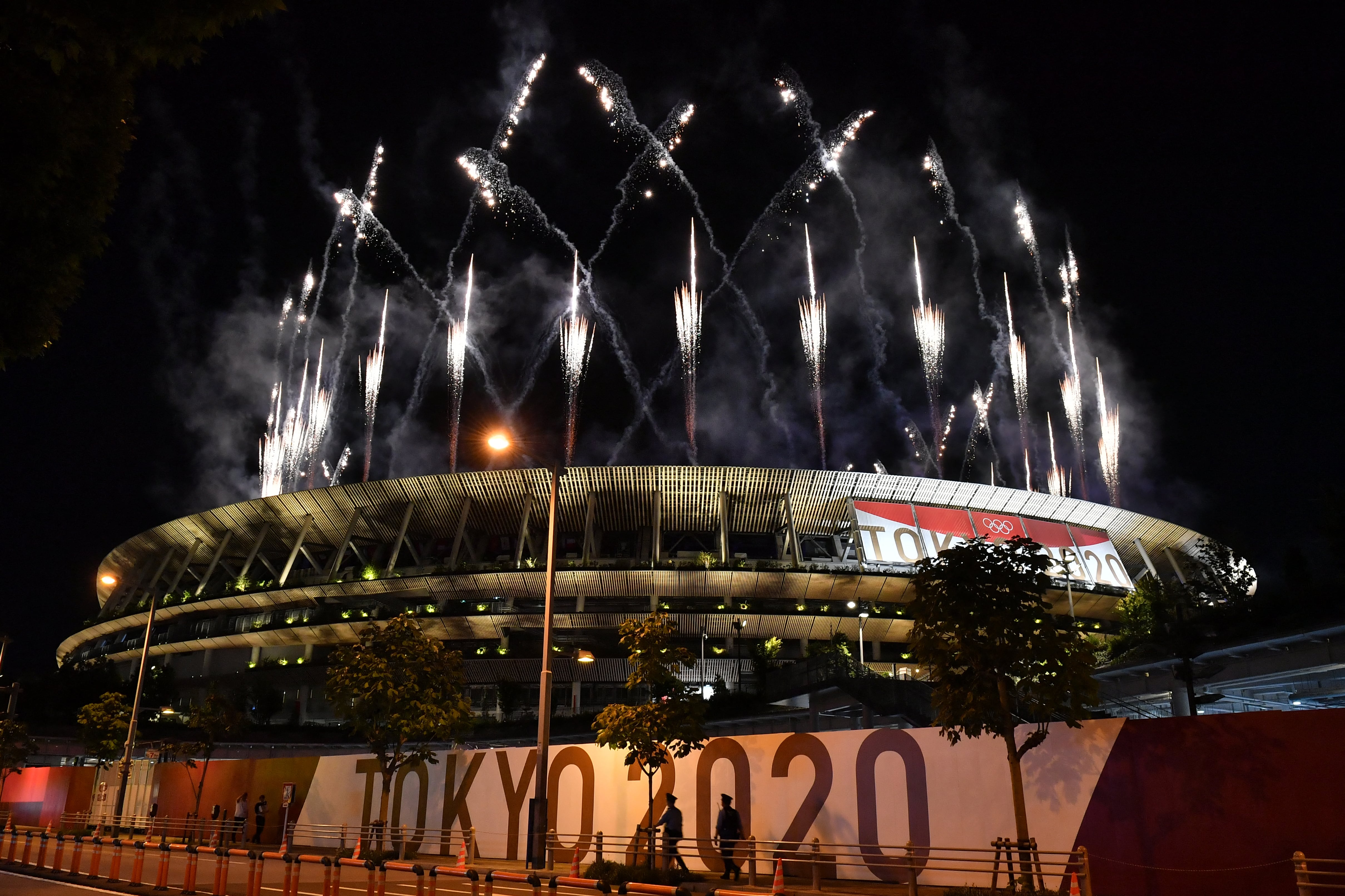 Los fuegos artificiales estallan alrededor del Estadio Olímpico durante la ceremonia de clausura de los Juegos Olímpicos de Tokio 2020, visto desde fuera de la sede en Tokio el 8 de agosto de 2021 (Foto de Kazuhiro NOGI / AFP).