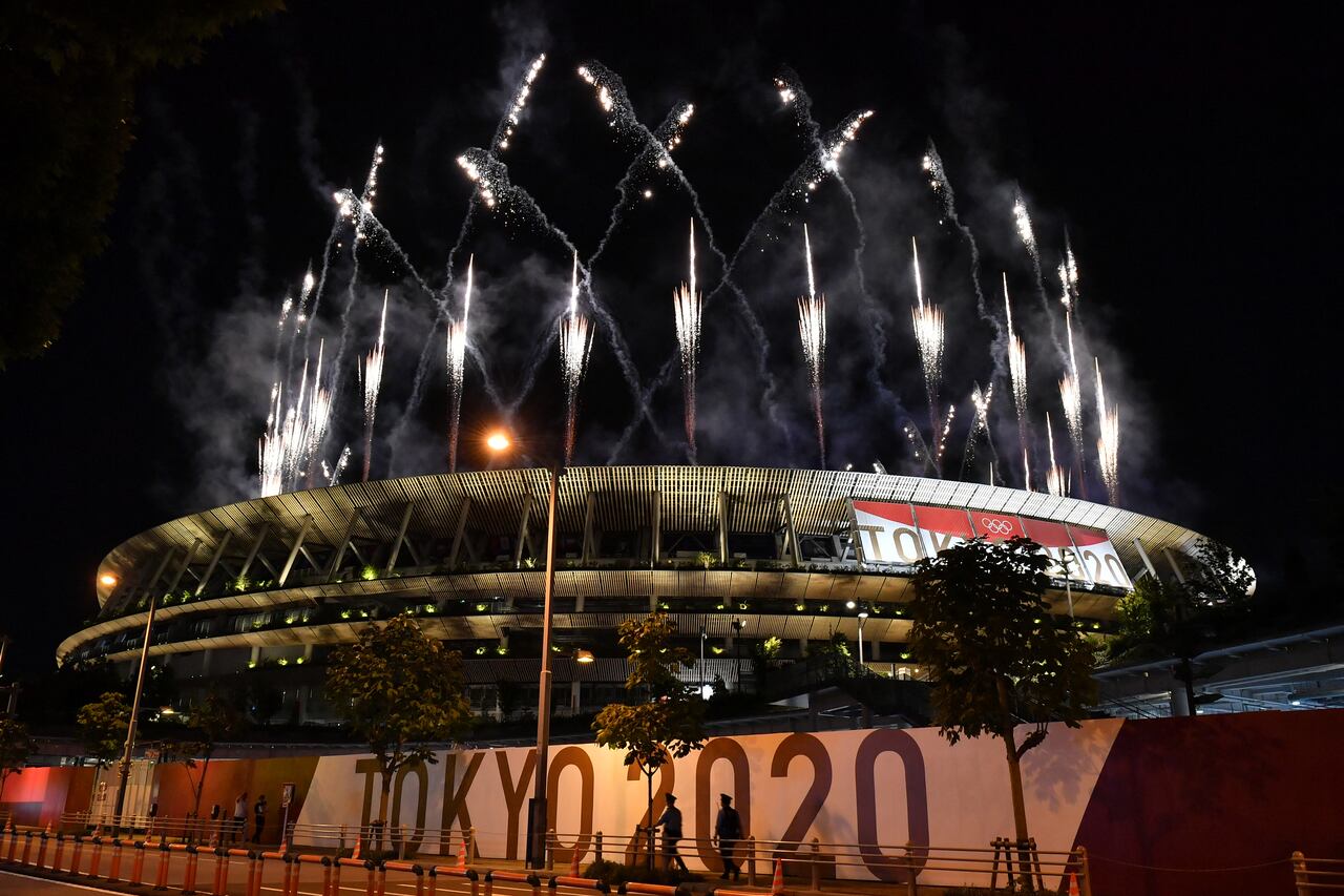 Los fuegos artificiales estallan alrededor del Estadio Olímpico durante la ceremonia de clausura de los Juegos Olímpicos de Tokio 2020, visto desde fuera de la sede en Tokio el 8 de agosto de 2021 (Foto de Kazuhiro NOGI / AFP).