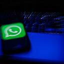 WhatsApp logo displayed on a phone screen and a laptop keyboard are seen in this long exposure illustration photo taken in Krakow, Poland on February 6, 2022. (Photo illustration by Jakub Porzycki/NurPhoto via Getty Images)