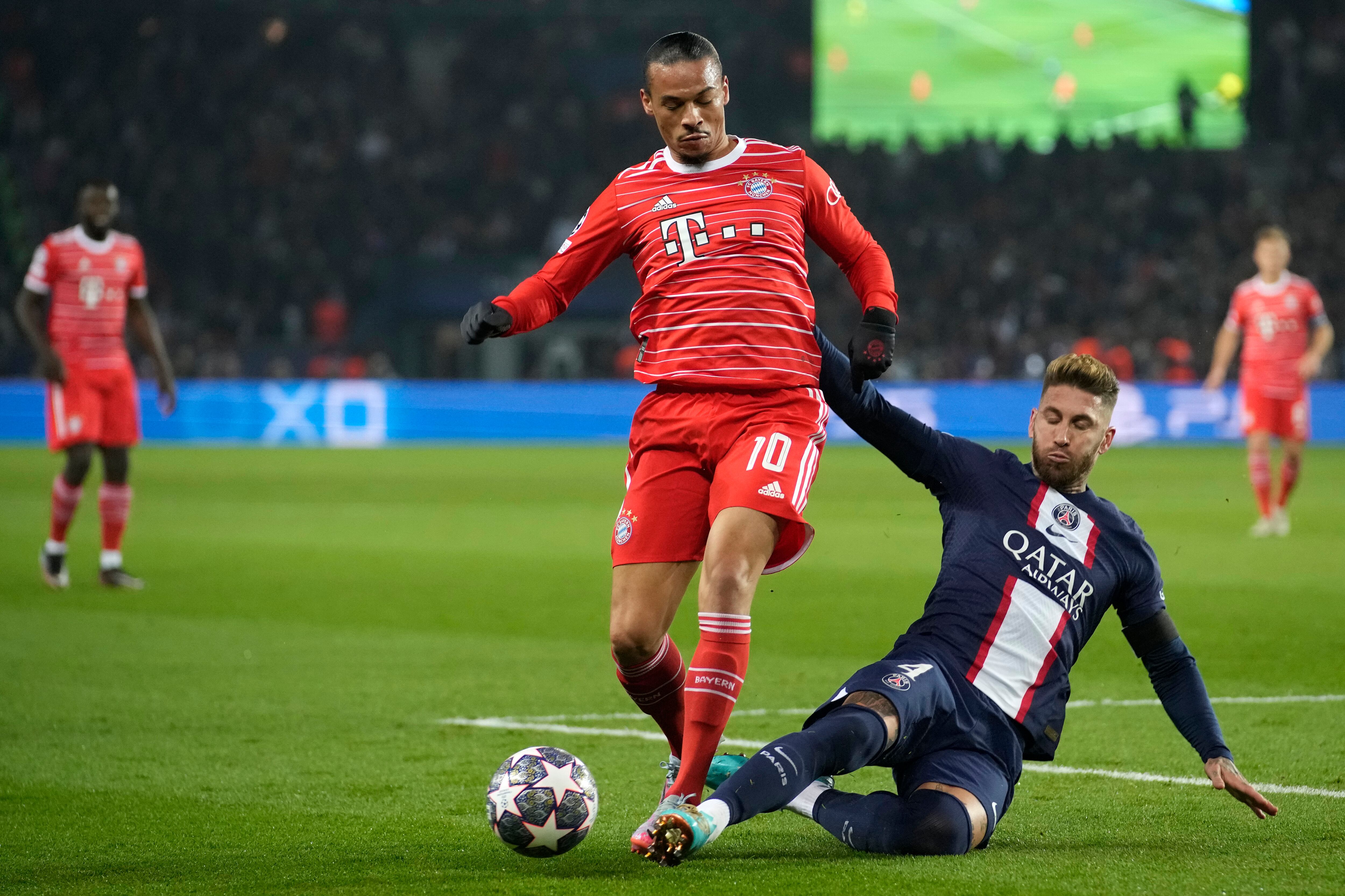 Bayern's Leroy Sane, left, duels for the ball with PSG's Sergio Ramos during the Champions League round of 16 first leg soccer match between Paris Saint Germain and Bayern Munich, at the Parc des Princes stadium, in Paris, France, Tuesday, Feb. 14, 2023. (AP Photo/Christophe Ena)
