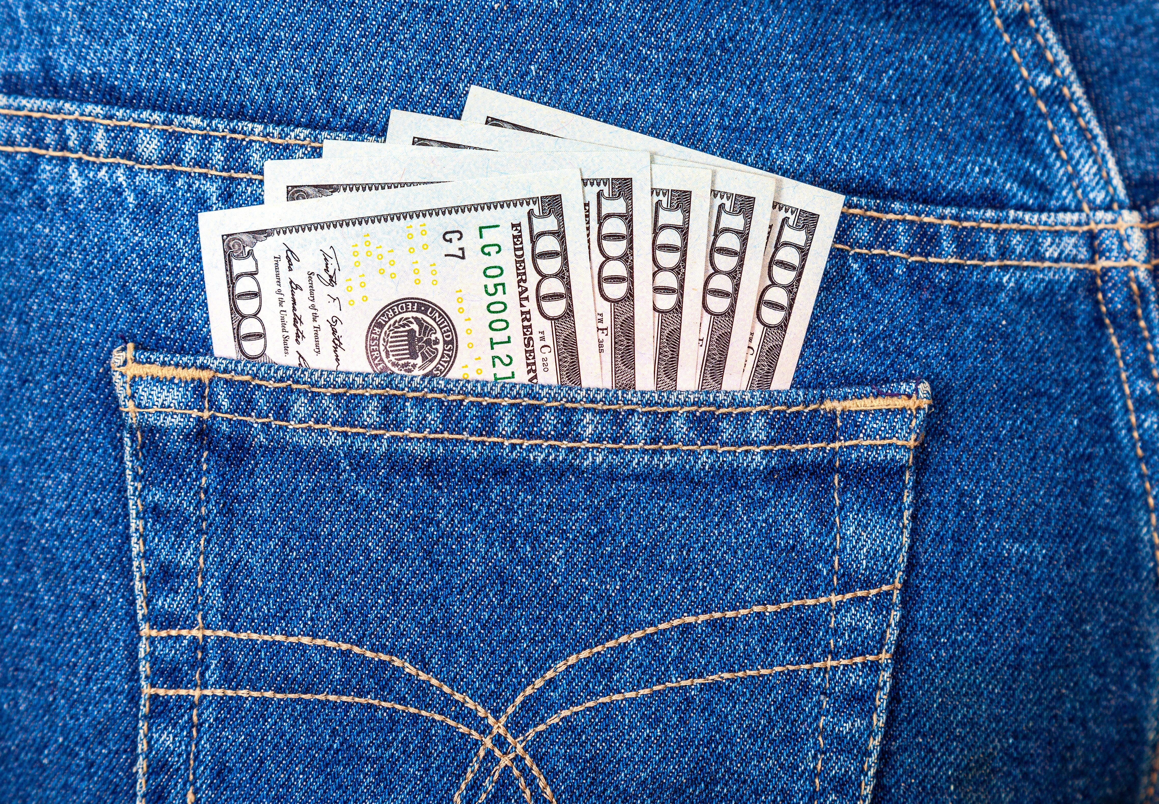 Bolsillo de pantalón de jean con billetes.