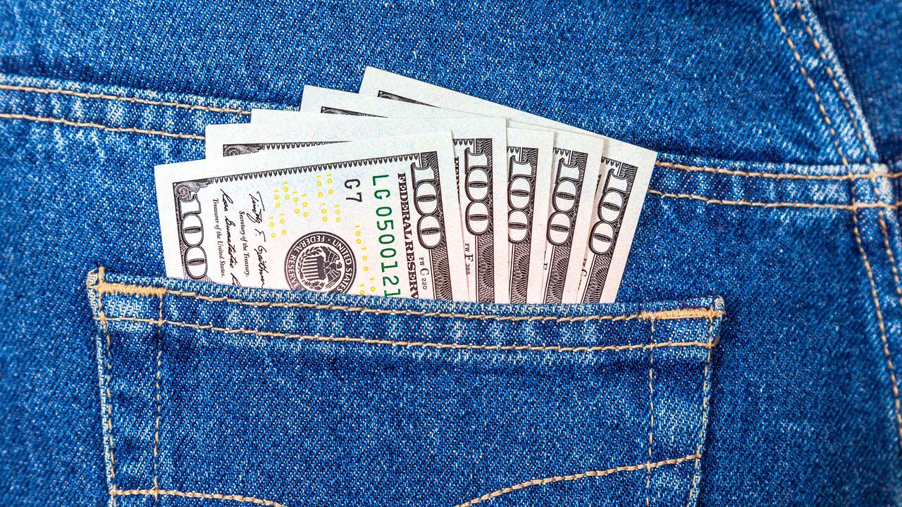 Bolsillo de pantalón de jean con billetes.
