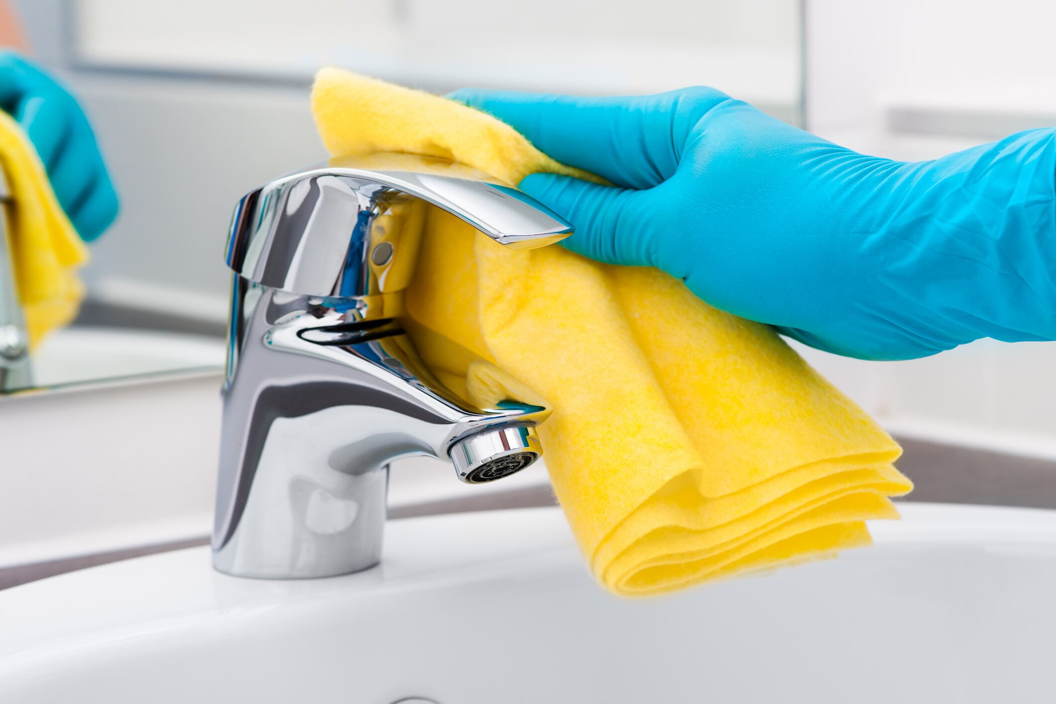 Woman doing chores in bathroom, cleaning tap