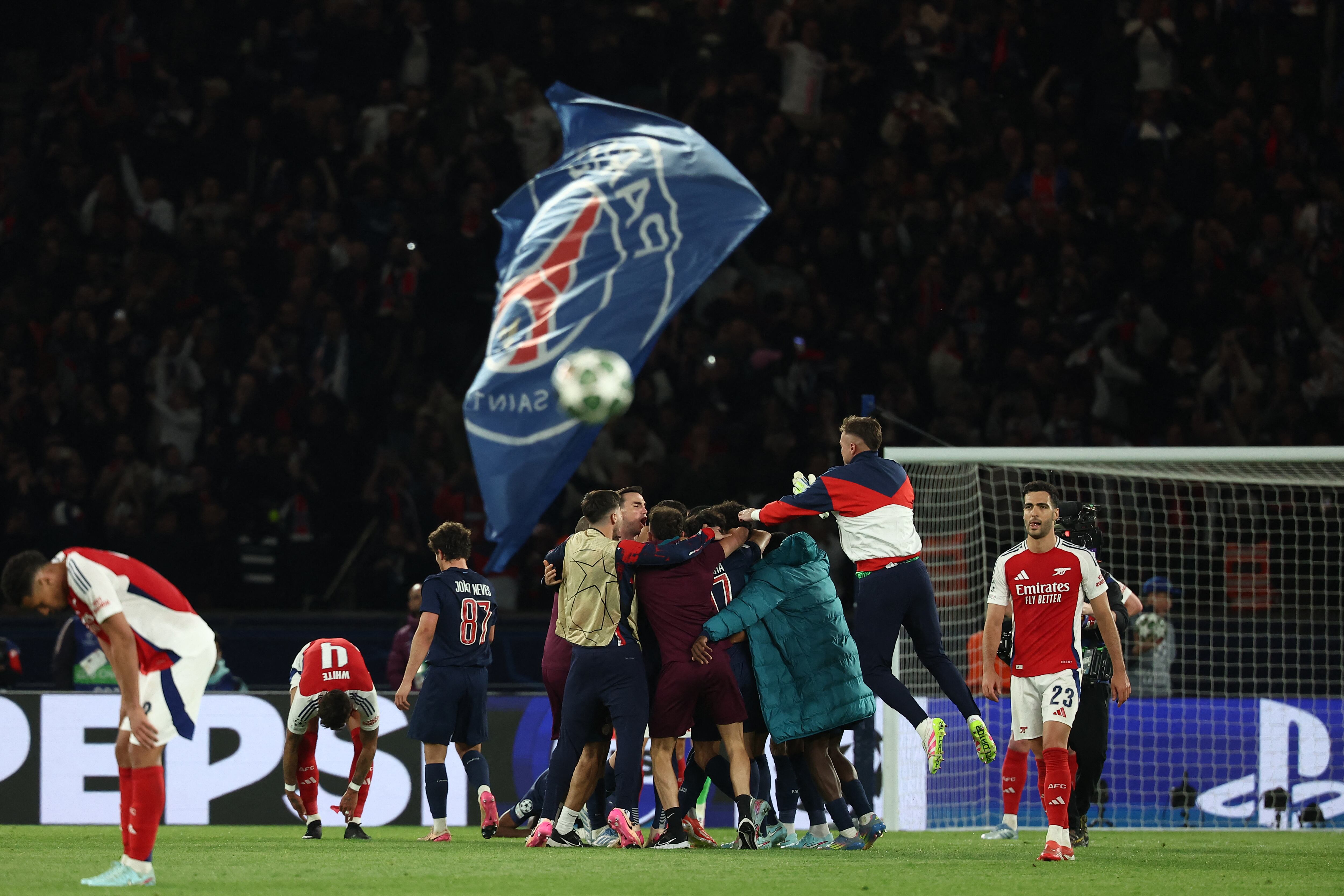 Los jugadores del Arsenal reaccionan mientras los jugadores del PSG celebran su victoria al final del partido de vuelta de la semifinal de la UEFA Champions League.