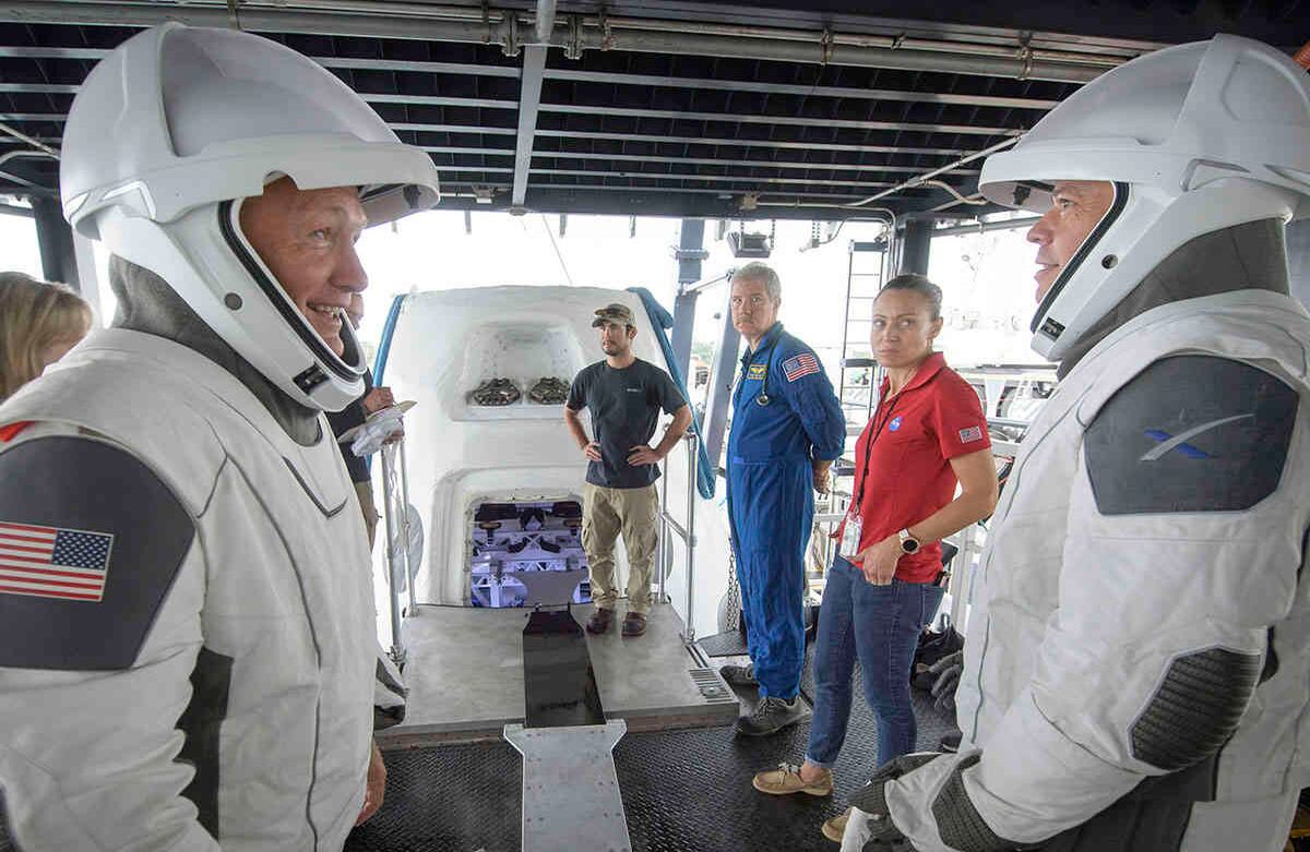 En esta foto de archivo del 13 de agosto de 2019, los astronautas de la NASA Doug Hurley, izquierda, y Bob Behnken junto con equipos de la agencia espacial y la empresa SpaceX ensayan cómo salir de la cápsula Crew Dragon que transportará a seres humanos a la Estación Espacial Internacional, en Cabo Cañaveral, Florida, EEUU. Foto: Bill Ingalls/NASA
