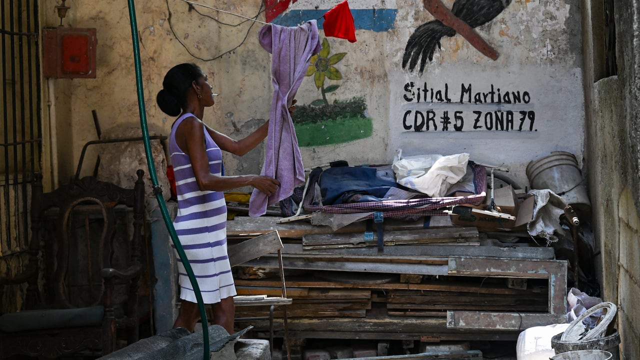 Una mujer toma una toalla de su tendedero en un terreno baldío en La Habana el 18 de mayo de 2026. El líder de Cuba advirtió el 18 de mayo sobre un "baño de sangre" en caso de un ataque estadounidense, mientras que el Tesoro de Estados Unidos sancionó a la principal agencia de inteligencia de Cuba y a los principales líderes a medida que aumentaban las tensiones entre los archienemigos. (Foto de YAMIL LAGE / AFP)