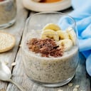 Durante la noche, plátano, avena, quinua, pudín de semillas de chía, decorado con rodajas de plátano fresco y chocolate.