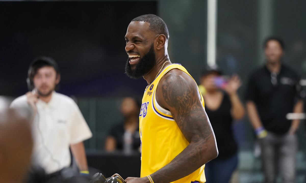 Los Angeles Lakers' LeBron James shares a laugh with staff members during the NBA basketball team's Media Day Monday, Sept. 26, 2022, in El Segundo, Calif. (AP/Jae C. Hong)