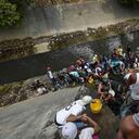 La falta de abastecimiento ha llevado a los venezolanos a recoger agua de los ríos. En esta escena, hay fila en el río Guaire, en Caracas, conocido por sus altos niveles de contaminación.