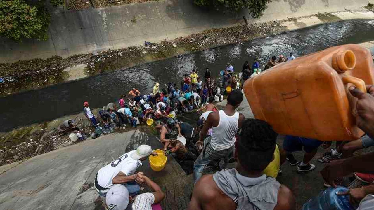 La falta de abastecimiento ha llevado a los venezolanos a recoger agua de los ríos. En esta escena, hay fila en el río Guaire, en Caracas, conocido por sus altos niveles de contaminación.