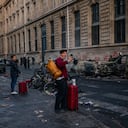Un turista utiliza su teléfono inteligente para grabar vehículos calcinados durante una jornada de protestas contra el «alto costo de la vida» en París, el 17 de octubre de 2026