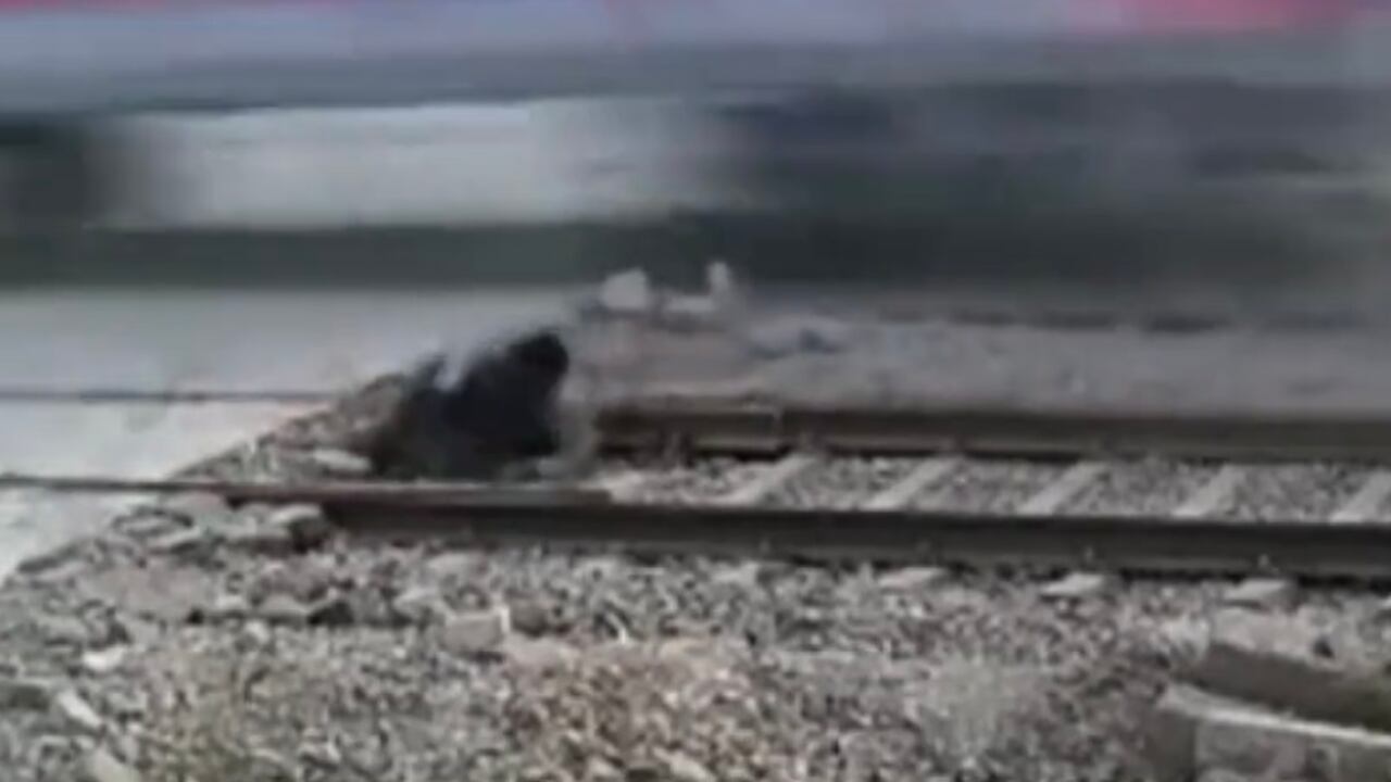 A pesar del susto, el motociclista se pone en pie y se aleja de la vía férrea, según se puede ver en la imágen tomada por una cámara de seguridad de la zona.
