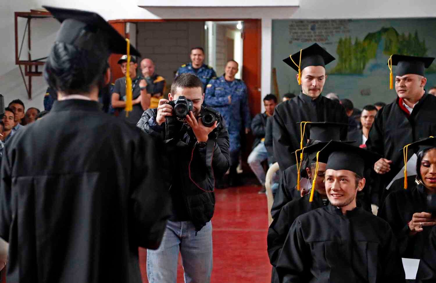 Los graduados posan con su diploma mientras los dragoneantes y familiares los observan entre el público.