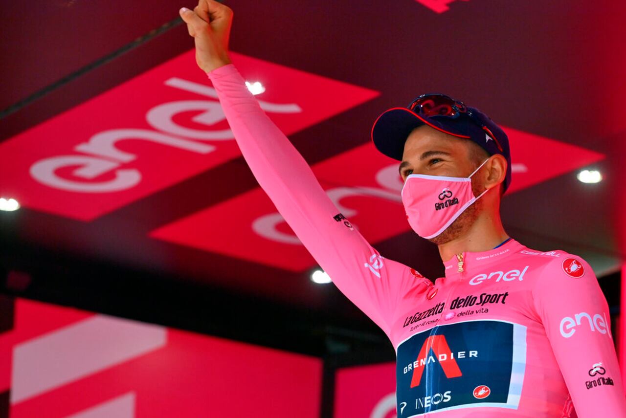 Italy's Filippo Ganna wears the pink jersey of the race overall leader as he celebrates on the podium after winning the opening stage of the Giro d'Italia, tour of Italy, cycling race, an individual time trial from Monreale to Palermo, Italy, Saturday, Oct. 3, 2020. (Marco Alpozzi/LaPresse via AP)