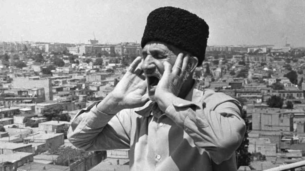 El Al moazin mira en dirección a la Meca, se cubre los oídos y canta "Acudid a la plegaria, acudid a la dicha".