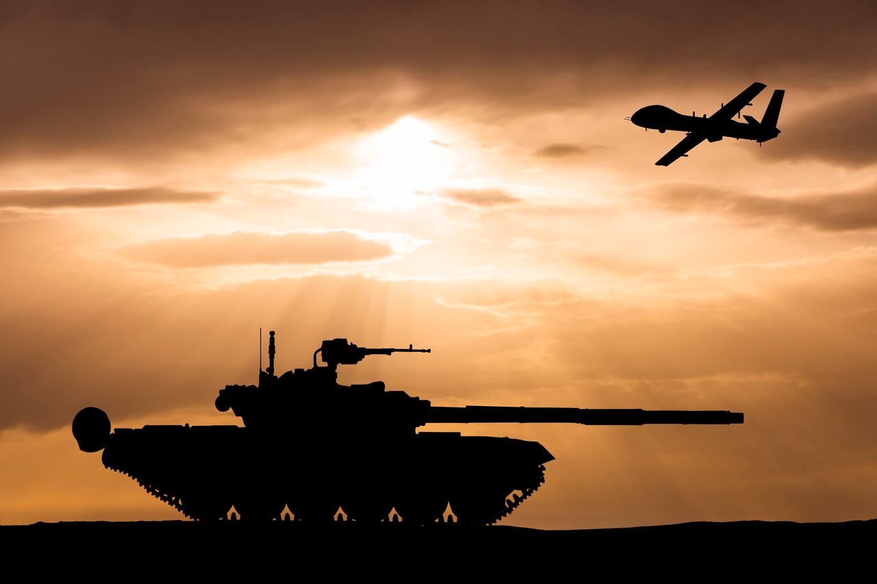 Armored tank and combat drone on the background of the sunset sky