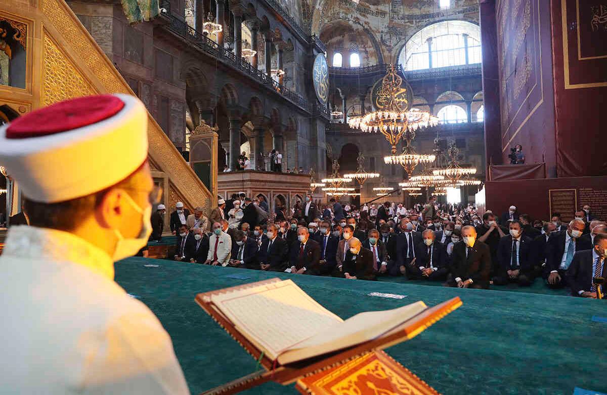 Un imán lee de Corán, el libro sagrado del Islam. Los dignatarios, incluido el presidente de Turquía, Recep Tayyip Erdogan, participan en las oraciones de los viernes en Hagia Sophia, en el distrito histórico de Sultanahmet de Estambul, el viernes 24 de julio de 2020. (Turkish Presidency via AP, Pool)