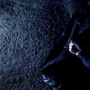 Policeman closing black body bag with corpse of victim, cruel murder on street